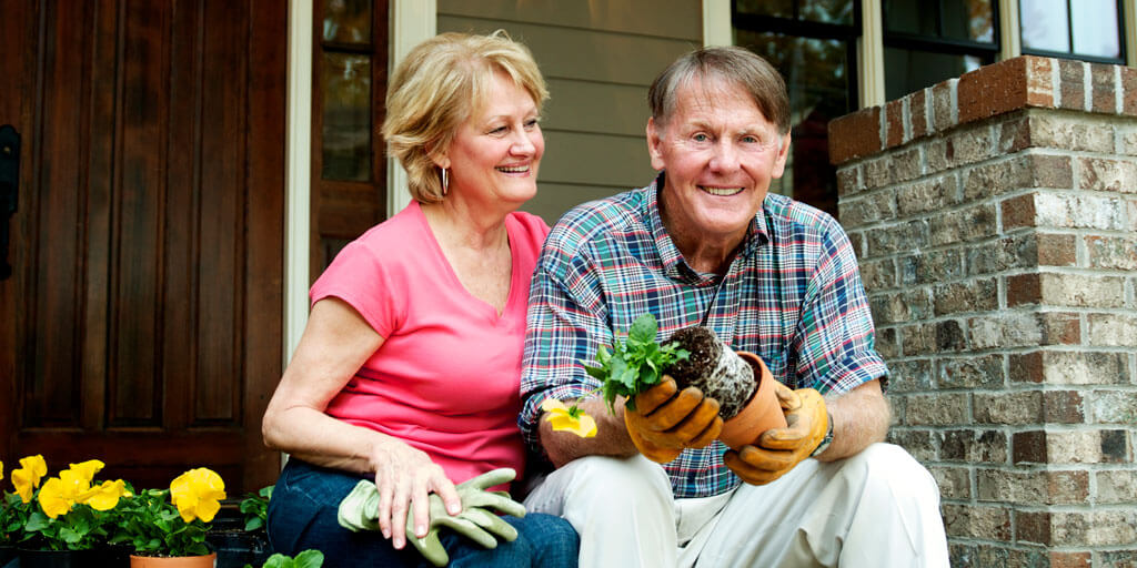 Senior couple without glasses planting outdoors