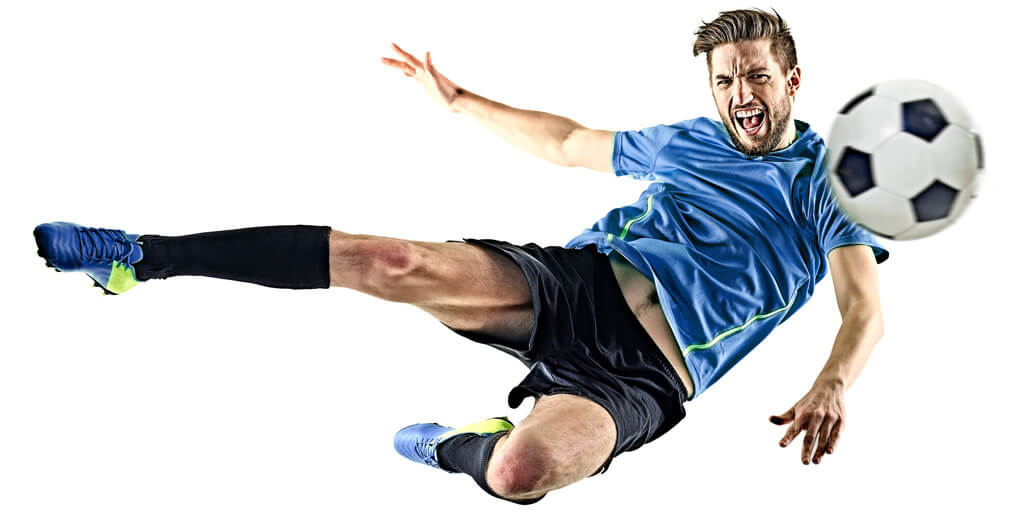 Athletic man kicking a soccer ball.