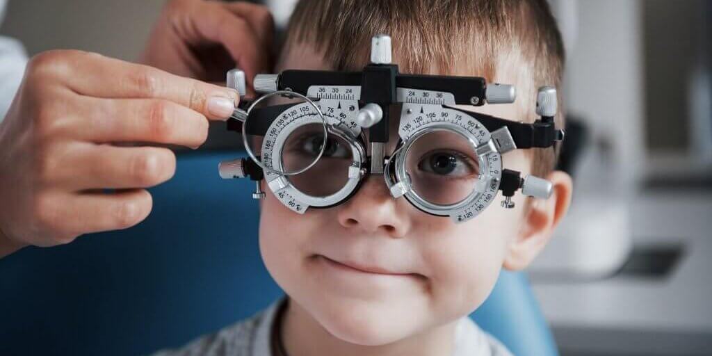 Tuning the intrument. Little boy with phoropter having testing his eyes in the doctor's office Tuning the intrument. Little boy with phoropter having testing his eyes in the doctor's office.