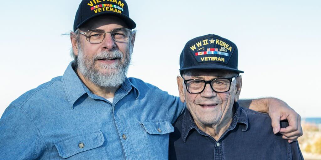 Senior men with glasses standing together looking at camera